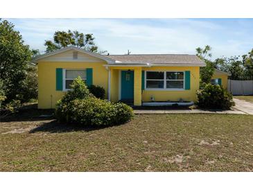 Charming home featuring a bright yellow exterior, blue door, and matching shutters at 1223 Union St, Clearwater, FL 33755