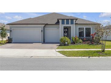 Beautiful one-story home with a two-car garage and a well-manicured lawn at 21396 Snowy Orchid Ter, Land O Lakes, FL 34637