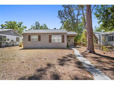 Charming single-story home with a stone walkway, natural shutters, and mature trees at 4218 2Nd S Ave, St Petersburg, FL 33711