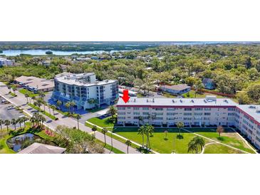 An aerial view of the condo complex, showcasing the beautiful lake and surrounding green landscape at 9950 62Nd N Ter # 319, St Petersburg, FL 33708