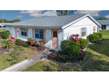 Charming single story home with well-maintained landscaping and peach accents at 1902 Andover St # 198, Sun City Center, FL 33573