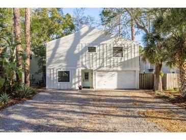 Charming two-story home featuring a light blue door and a spacious driveway at 314 Ontario Ave, Crystal Beach, FL 34681