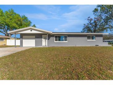 Charming single-story home featuring a well-maintained lawn, attached garage, and neutral gray exterior paint at 6835 114Th St, Seminole, FL 33772