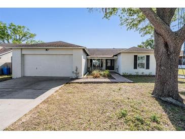 Charming single-story home with white brick, well-kept lawn, and a two-car garage at 803 Greenbelt Cir, Brandon, FL 33510