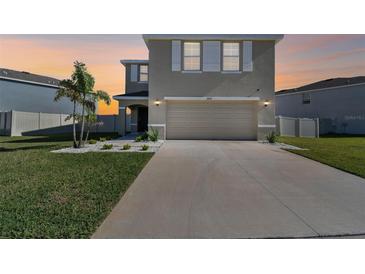 Beautiful two-story home featuring a two-car garage, neutral paint, and manicured front lawn at 16614 Mosaic Oar Dr, Wimauma, FL 33598