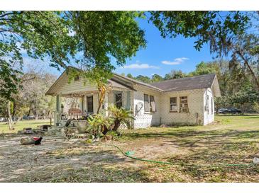 Charming single-story home with a covered porch and lots of surrounding trees at 22295 Powell Rd, Brooksville, FL 34602