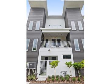 Modern three-story townhome with a balcony and well-maintained landscaping creates an inviting exterior at 41 29Th N St, St Petersburg, FL 33713