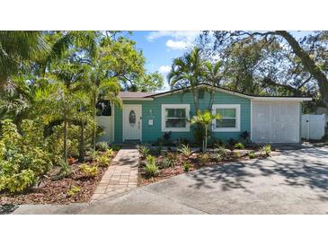 Charming curb appeal with a freshly painted home, brick pathway, and lush tropical landscaping at 4750 Burlington N Ave, St Petersburg, FL 33713