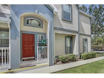 Inviting townhome exterior showcases a red front door and charming architectural details at 6036 Fishhawk Crossing Blvd, Lithia, FL 33547