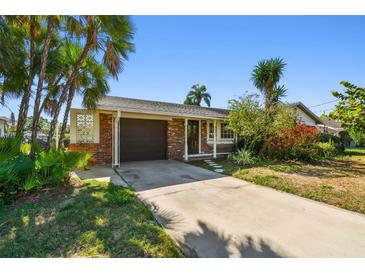 Charming single-story home with a brick facade and a driveway leading to a garage at 8706 Tahiti Ln, Tampa, FL 33615
