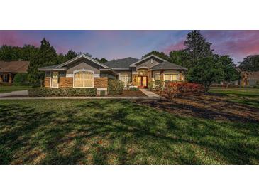 Charming single-story home with stone accents, lush landscaping, and a well-manicured lawn at 19719 Prince Benjamin Dr, Lutz, FL 33549