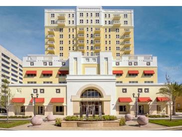 Low angle view of the exterior of a light yellow and white 13-story Station Square building on a bright day at 628 Cleveland St # 907, Clearwater, FL 33755