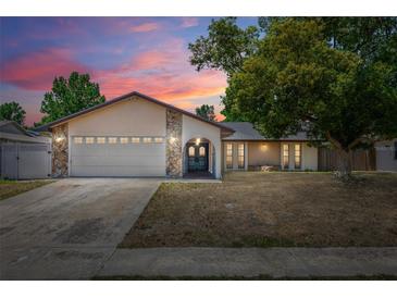Charming single-story home with stone accents, double-door entry, manicured lawn, and attached two-car garage at 8329 Broken Willow Ln, Port Richey, FL 34668