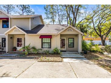 Charming townhouse with a red awning, neat landscaping, and a well-maintained concrete driveway at 8409 Laurelon Pl # 8409, Temple Terrace, FL 33637