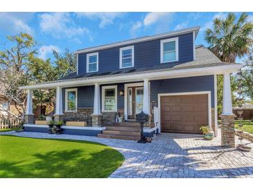 Charming blue two-story home with a welcoming front porch, beautiful stone accents, and well-manicured lawn at 2005 Jackson N St, St Petersburg, FL 33704