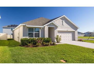 Charming one-story home featuring a well-manicured lawn, tasteful landscaping, and an attached two-car garage at 31399 Penny Surf Loop, Wesley Chapel, FL 33545