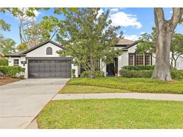 Beautifully landscaped yard featuring mature shade trees and a well-maintained lawn surrounding a two-story home at 3709 W Horatio St, Tampa, FL 33609