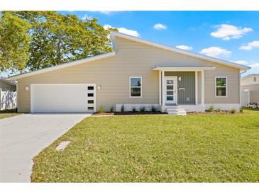 Charming home with an attached garage, manicured lawn, and modern architectural details at 3860 Whiting Se Dr, St Petersburg, FL 33705