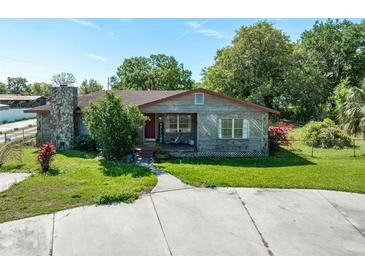 Attractive single-story home with stone chimney, well-kept lawn, and inviting front porch at 1501 W Trapnell Rd, Plant City, FL 33566