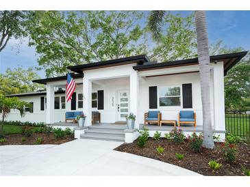 Charming single-story home featuring a welcoming front porch with an American flag at 3520 Poplar Ne St, St Petersburg, FL 33704