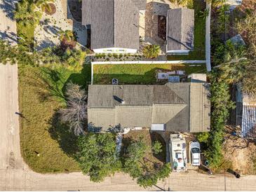 Aerial view of home showing the roof, yard, other buildings, an RV, and cars, surrounded by a white fence at 4509 27Th S Ave, Gulfport, FL 33711