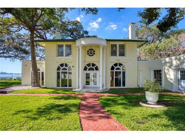 Stately two-story home featuring a manicured lawn, brick walkway, and classic architectural details at 800 Druid S Rd, Clearwater, FL 33756