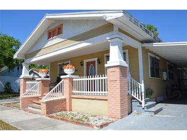 Charming, historic home with a covered porch, decorative columns, and well-maintained landscaping at 2222 Harper St, Tampa, FL 33605