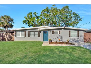 Charming single-story home featuring a well-manicured lawn and blue front door at 6208 Florida W Cir, Apollo Beach, FL 33572