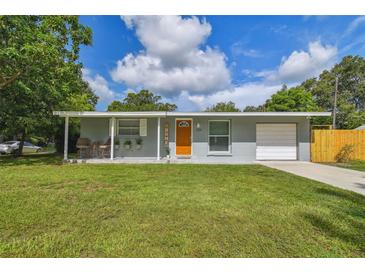 Charming single-story home with a well-manicured lawn, a covered front porch, and an attached garage at 1260 S Hillcrest Ave, Clearwater, FL 33756
