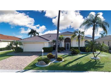 Charming single-story home featuring lush landscaping, a brick driveway and a neutral color palette at 1308 Crystal Greens Dr, Sun City Center, FL 33573