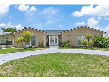 Charming single-story home featuring a circular driveway, decorative front door, and mature landscaping at 13701 Garris Dr, Hudson, FL 34667