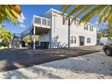 Two-story home featuring siding, a second story deck, and an asphalt and stone driveway at 14924 Old Dixie Hwy, Hudson, FL 34667