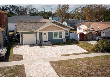 Charming single-Gathering home showcasing updated facade, landscaping, and large brick paved driveway at 1510 49Th N St, St Petersburg, FL 33710