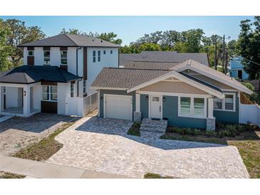 Charming blue craftsman style home featuring a brick driveway, attached garage, and manicured landscaping at 1510 49Th N St, St Petersburg, FL 33710