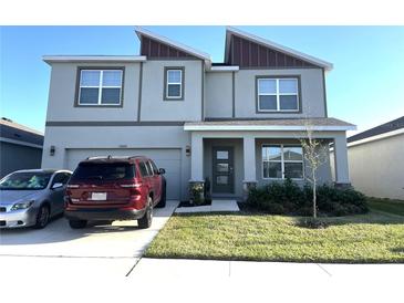 Modern two-story home showcasing a well-manicured lawn, stylish windows, and a welcoming front porch at 31888 Treasure Dock Isle, Wesley Chapel, FL 33545