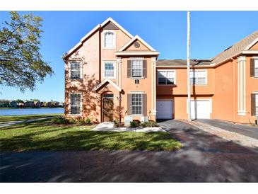Charming two-story townhome featuring a well-maintained lawn and a serene lake view at 9008 Lake Chase Island Way, Tampa, FL 33626