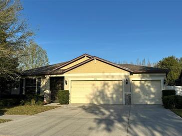 Well-maintained single-story home featuring an attached three-car garage, manicured landscaping, and a concrete driveway at 2206 Landside Dr, Valrico, FL 33594