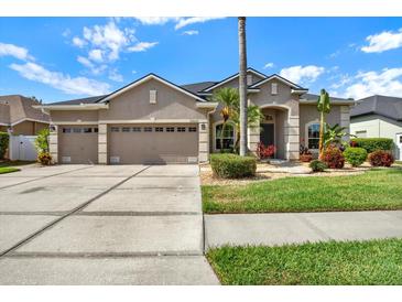 Charming home featuring a three car garage, well-manicured lawn, and inviting landscaping at 22647 Eagles Watch Dr, Land O Lakes, FL 34639