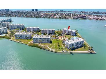 Stunning aerial view of waterfront condo complex surrounded by lush landscaping and picturesque water views at 8040 Sailboat Key S Blvd # 402, St Pete Beach, FL 33707