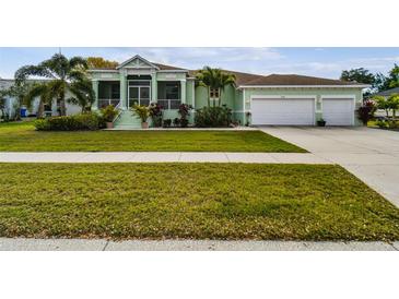 Charming single-Gathering home with a well-manicured lawn, two car garage, and screened front porch at 834 Birdie Way, Apollo Beach, FL 33572