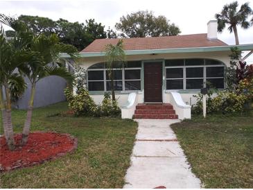 Charming single-story home features a brick entryway, arched windows, and lush landscaping in the front yard at 1876 Mississippi Ne Ave, St Petersburg, FL 33703