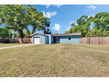 Charming single-story home with a well-maintained lawn, attached garage, and inviting blue exterior at 2035 Ronald Cir, Seffner, FL 33584