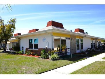 Charming condo featuring updated exterior with a well-manicured lawn and cozy front porch at 4338 Tahitian Gardens Cir # H, Holiday, FL 34691