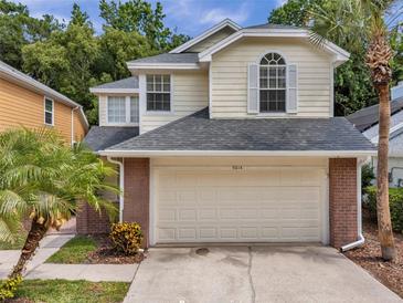Charming two-story home with a two-car garage and brick accents, complemented by lush palm trees at 5014 Sterling Manor Dr, Tampa, FL 33647