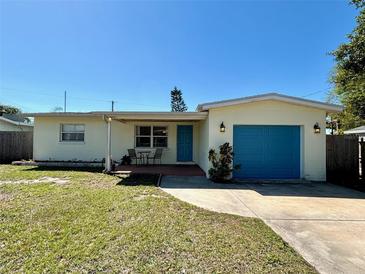 Charming single-story home with a bright blue front door and attached one car garage at 5436 Jaguar Ln, Holiday, FL 34690