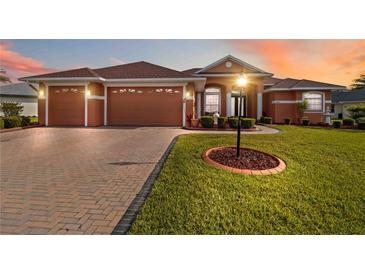 Charming single-story home with manicured lawn, brick driveway, and well-lit exterior showcasing curb appeal at 5444 90Th Avenue E Cir, Parrish, FL 34219