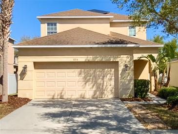 Two-story home with a two-car garage, a neutral color palette, and a well-maintained front yard at 8314 Deerland Bluff Ln, Riverview, FL 33578