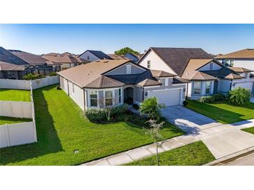 Well maintained gray single Gathering home with beautiful landscaping and a two-car garage at 9748 Ibis Grove Blvd, Wesley Chapel, FL 33545
