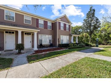 Charming townhome featuring red shutters, well-kept landscaping, and a cozy front porch area at 11047 Black Swan Ct, Seffner, FL 33584