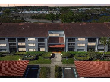 This aerial view showcases the well-maintained building with lush landscaping and ample parking at 2595 Countryside Blvd # 8-305, Clearwater, FL 33761